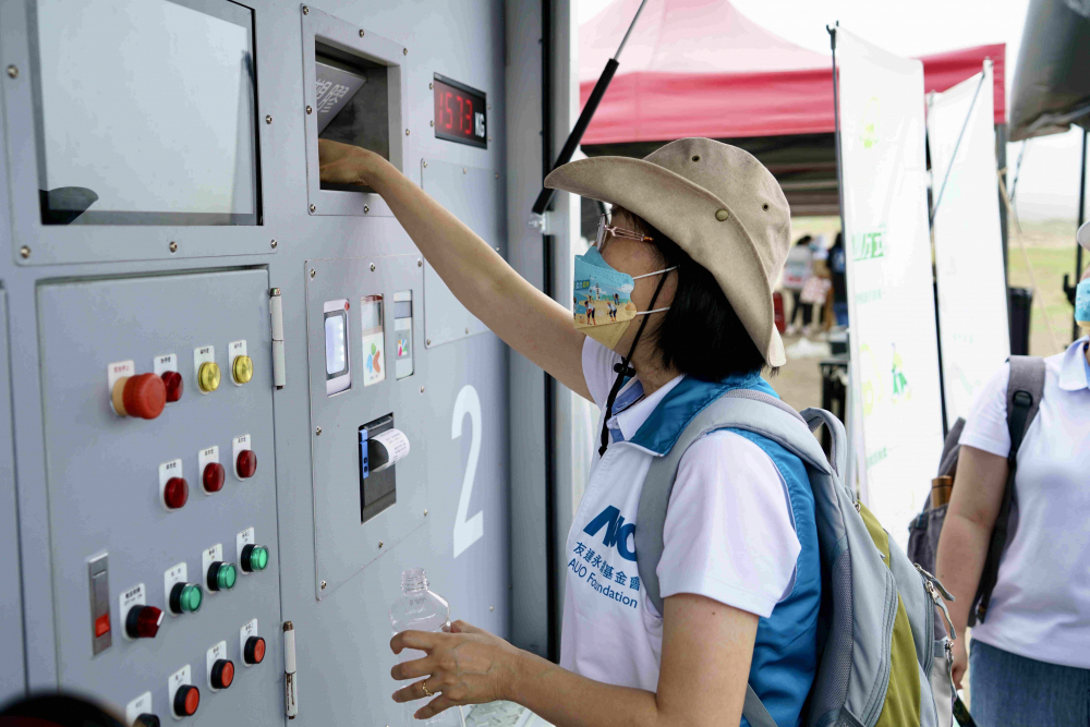 志工們將拾起的寶特瓶投入「好歸塑專車」，讓廢棄塑料空瓶可以直接粉碎、縮小體積，未來將可再製成購物袋、寶特衣、悠遊卡等生活用品